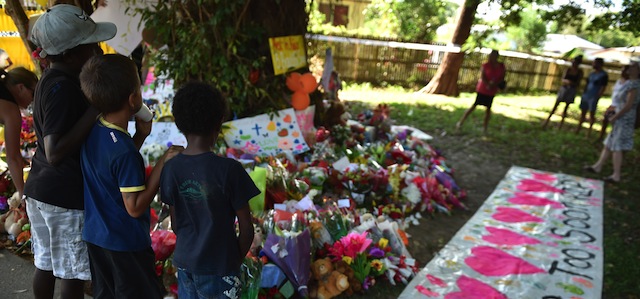 This photo taken on December 20, 2014 shows local children at a makeshift memorial at the scene where eight children ranging from babies to teenagers were found dead in a house in the northern Australian city of Cairns. Australian police said on December 20 that they had arrested the mother of all but one of eight children reportedly stabbed to death as vigils were held to mourn the tragedy. AFP PHOTO/Peter PARKS (Photo credit should read PETER PARKS/AFP/Getty Images)