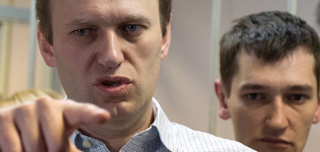 Russian anti-Kremlin opposition leader Alexei Navalny (L) gestures next to his brother and co-defendant Oleg as they attend the verdict announcement of their fraud trial at a court in Moscow on December 30, 2014. Russia's top opposition leader Alexei Navalny on December 30 called for mass protests to "destroy" President Vladimir Putin's regime after a court handed him a suspended sentence but jailed his brother in a controversial fraud case. In a lightning hearing that was abruptly brought forward by two weeks, a judge found both Navalny and his brother Oleg guilty of embezzlement and sentenced the siblings to three and a half years in what is widely seen as a politically motivated case. AFP PHOTO / DMITRY SEREBRYAKOV (Photo credit should read DMITRY SEREBRYAKOV/AFP/Getty Images)