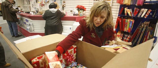 ** STAND ALONE PHOTO ** Maria Plante, from Smithfield, R.I., packs a box of Christmas presents she is sending to relatives in Italy, at the main Post Office in Providence, R.I., Monday, Dec.. 17, 2007. According to United States Postal officials, Monday is the busiest day of the season as people rush to send out last-minute items and cards to friends and family. (AP Photo/Stew Milne)