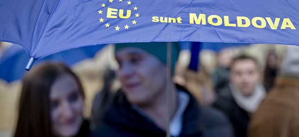 Moldovan students hold an umbrella that uses the European Union symbol to form the sentence "I am Moldova" after arriving in the Romanian capital to vote, at the main railway station, Gara de Nord, in Bucharest, Romania, Sunday, Nov. 30, 2014. Moldovans vote in elections where they are choosing between parties that want to move closer to Europe and those that want to move back into Russia's orbit.Sunday's parliamentary election takes on wider significance with the unrest in neighboring Ukraine. Moldova, like Ukraine, has a pro-Russia separatist region in its east.(AP Photo/Vadim Ghirda)