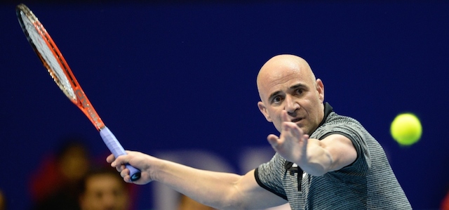 Lo statunitense Andre Agassi dei Singapore Slammers contro l'australiano Mark Philippoussis dei Manila Mavericks all'International Premier Tennis League, Singapore, 2 dicembre 2014. 
(ROSLAN RAHMAN/AFP/Getty Images)