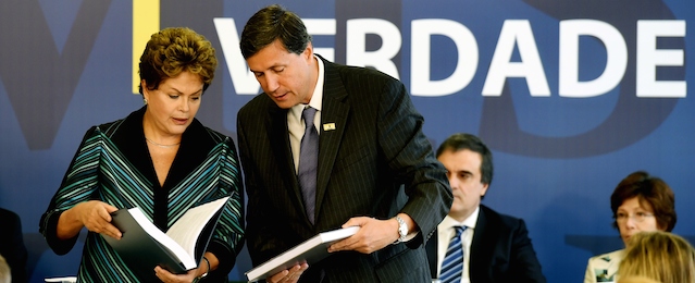 Brazilian President Dilma Rousseff (L) receives from the Coordinator of the National Truth Commission (CNV) Pedro Dallari, the CNV final report --on the investigation of those responsible for human rights violations between 1946 and 1988 in the country-- at the Planalto Palace in Brasilia, Brazil, on December 10, 2014. The report lists those responsible for political repression and admits --for the first time-- the disappearance of 434 people during the dictatorship. The disclosure of the document accompanies the International Human Rights Day commemoration. It also includes a list of places where forced interrogation, illegal arrests and enforced disappearances took place. AFP PHOTO/EVARISTO SA (Photo credit should read EVARISTO SA/AFP/Getty Images)