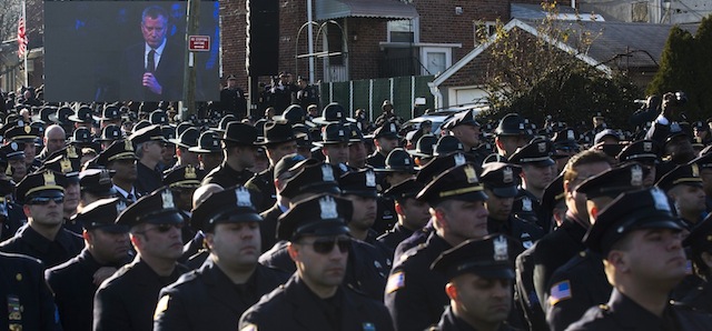 Un gruppo di agenti si volta di spalle durante il discorso del sindaco di New York Bill de Blasio (AP Photo/John Minchillo)