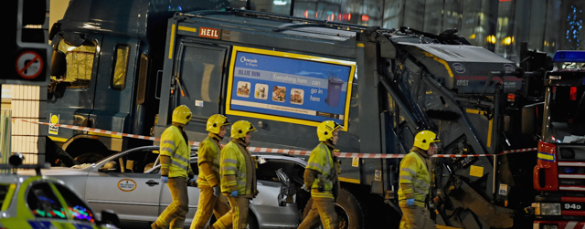 GLASGOW, SCOTLAND - DECEMBER 22: Emergency services walk past a cordon off crashed bin lorry as they attend the scene of the crash in George Square on December 22, 2014 in Glasgow, Scotland. There are reports of a number of fatalities and substantial casualties after a bin lorry appears to have crashed into pedestrians in George Square. (Photo by Jeff J Mitchell/Getty Images)