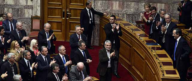 Greek Prime Minister Antonis Samaras (R) is applauded by lawmakers as he arrives for the first round of a three-stage presidential election in Greece, on December 17, 2014 . Greece's high-stakes presidential election -- and concerns about the future of its fiscal reforms -- went into a second round on December 17 after parliament failed to pick a head of state in a first ballot. The coalition government of Prime Minister Antonis Samaras failed to muster the required 200 out of 300 MPs to elect its nominee, former EU Environment Commissioner Stavros Dimas, meaning a second vote will be held on December 23. AFP PHOTO/ LOUISA GOULIAMAKI (Photo credit should read LOUISA GOULIAMAKI/AFP/Getty Images)