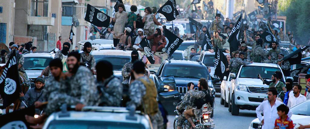 This undated image posted by the Raqqa Media Center, a Syrian opposition group, on Monday, June 30, 2014, which has been verified and is consistent with other AP reporting, shows fighters from the al-Qaida linked Islamic State of Iraq and the Levant (ISIL) during a parade in Raqqa, Syria. Militants from an al-Qaida splinter group held a military parade in their stronghold in northeastern Syria, displaying U.S.-made Humvees, heavy machine guns, and missiles captured from the Iraqi army for the first time since taking over large parts of the Iraq-Syria border. (AP Photo/Raqqa Media Center)