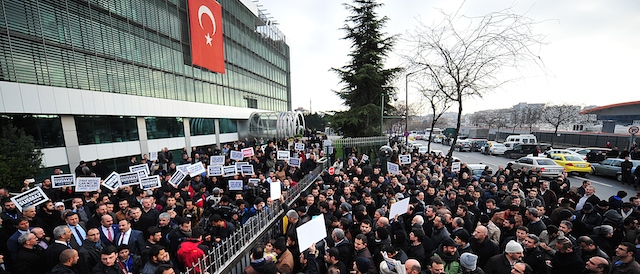 Staff members and supporters of Zaman newspaper protest against a raid by counter-terror police outside the newspaper headquarters in Istanbul on December 14, 2014. Turkish police launched a sweeping operation to arrest supporters of President Recep Tayyip Erdogan's rival, US-exiled imam Fethullah Gulen, including a raid on the offices of the Zaman daily, which is close to the cleric. A huge crowd gathered outside the offices of Zaman on the outskirts of Istanbul, creating a small stampede and forcing the police to leave the building without detaining any newspaper employees. AFP PHOTO/OZAN KOSE (Photo credit should read OZAN KOSE/AFP/Getty Images)