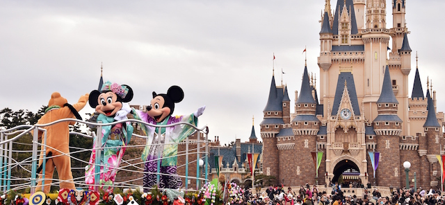 Disney characters Mickey (R) and Minnie Mouse (C), dressed in traditional Japanese kimonos, and Pluto (L) wave to greet guests from a float during the theme park's annual New Year's Day parade at Tokyo Disneyland in Urayasu, suburban Tokyo on January 1, 2015. The time around New Year's Day is one of the biggest holiday periods every year in Japan. AFP PHOTO / Yoshikazu TSUNO (Photo credit should read YOSHIKAZU TSUNO/AFP/Getty Images)