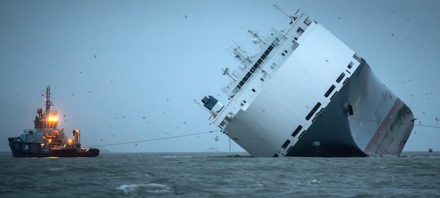 COWES, ENGLAND - JANUARY 07: Salvage tugs tow the stricken vessel 'Hoegh Osaka' to a anchor point in the the Solent on January 7, 2015 in Cowes, England. The ship began to float this afternoon and the salvagers of the Hoegh Osaka, a 52,000 ton cargo ship which is carrying 1,400 cars and plant machinery, moved the ship from the sand bank where she had been grounded since Saturday night.√ä (Photo by Matt Cardy/Getty Images)
