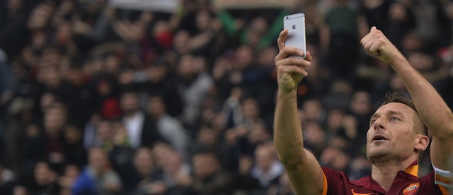 Roma's forward Francesco Totti celebrates and takes a picture with a mobile phone after scoring a second goal during the Italian Serie A football match on January 11, 2015 at Rome's Olympic stadium. AFP PHOTO / ANDREAS SOLARO (Photo credit should read ANDREAS SOLARO/AFP/Getty Images)