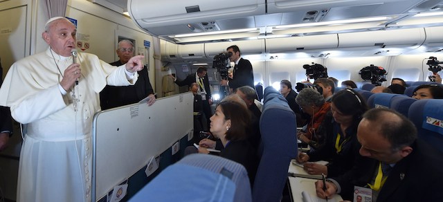 Pope Francis addresses journalist sitting onboard a plane during his trip back to Rome, on January 19, 2015 from the Philippines. The 78-year-old pontiff wrapped up a triumphant visit to the Philippines and Sri Lanka, seeking to promote the Catholic Church in one of its most important growth regions. AFP PHOTO / GIUSEPPE CACACE (Photo credit should read GIUSEPPE CACACE/AFP/Getty Images)
