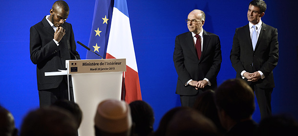Lassana Bathily, a man of Malian origin described as a "hero" after he helped hostages at a Jewish supermarket hide during the recent Paris attacks (L) speaks as French Prime Minister Manuel Valls (R) and Interior Minister Bernard Cazeneuve look on during a ceremony at which Bathily was awarded French nationality in Paris on January 20, 2015. Lassana Bathily, who has lived in France since 2006, was awarded French nationality for his bravery during the attacks. 
AFP PHOTO / ERIC FEFERBERG (Photo credit should read ERIC FEFERBERG/AFP/Getty Images)