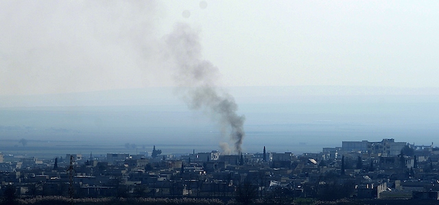 A picture taken on January 26, 2015 in Sanliufra shows smoke billowing from the Syrian town Kobane, also known as Ain al-Arab, following clashes between Kurdish forces and Islamic State (IS) groups. Kurdish fighters have expelled Islamic State group militants from the Syrian border town of Kobane, a monitor and spokesman said today, dealing a key symbolic blow to the jihadists' ambitions. AFP PHOTO / STRINGER
 (Photo credit should read -/AFP/Getty Images)