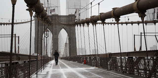 NEW YORK, NY - JANUARY 26: A lone person walks across the Brooklyn Bridge in heavy snow on January 26, 2015 in New York City. Much of the Northeast is bracing for a major winter storm which is expected to bring blizzard conditions and 10 to 30 inches of snow. New York City Mayor Bill de Blasio announced that only emergency vehicles will be allowed on area roads after 11pm. (Photo by Spencer Platt/Getty Images)