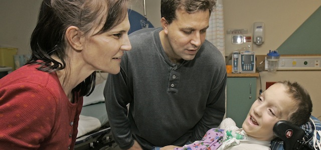 Beth and Kevin Malarkey, left to right, talk with their son Alex after surgery at University Hospitals Case Western Reserve Medical Center Friday, Jan. 9, 2009, in Cleveland. Alex Malarkey, 10, paralyzed in a car crash became the youngest person to receive a device tested by the late "Superman" actor Christopher Reeve that allows patients to breathe without a ventilator. (AP Photo/Tony Dejak)