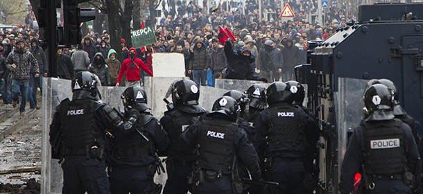 Protesters throw stones at the police in riot gear in Kosovo capital Pristina during a protest on Tuesday, Jan. 27, 2015. Police in Kosovo fired volleys of tear gas and used water cannons Tuesday to disperse thousands of stone-throwing anti-government protesters demanding the resignation of a minister who had denied that war crimes were committed against ethnic Albanians during the 1998-99 war with Serbia. At least 37 people were injured, including 22 policemen, during a series of clashes in city streets between riot police and protesters, officials said. The protesters pelted officers with stones, Molotov cocktails and other objects, in what is one of the worst bouts of violence to hit Kosovo since this former Serbian province declared its independence in 2008. (AP Photo/Visar Kryeziu)