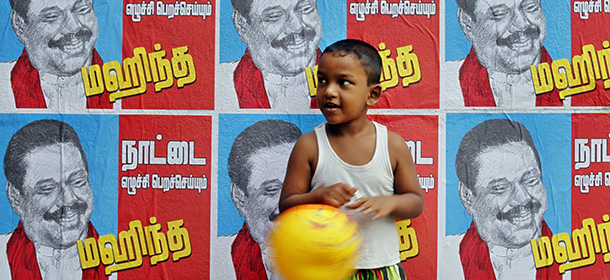 A Sri Lankan boy stands next to a wall pasted with election campaign posters of Sri Lankan President Mahinda Rajapaksa in Colombo, Sri Lanka, Wednesday, Dec. 31, 2014. Sri Lanka's main ethnic Tamil political party said that it will support opposition candidate Maithripala Sirisena in January's presidential election, in the latest blow to Mahinda Rajapaksa's bid for a third term in office. Posters read "Let us make the country rise - Mahinda!" (AP Photo/Eranga Jayawardena)