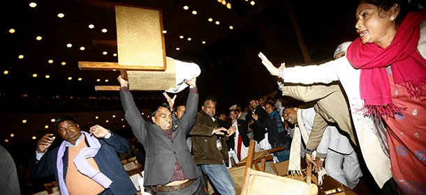 An unidentified Nepalese politician from the opposition party lifts a chair to throw, during the Constituent Assembly meeting, in Kathmandu, Nepal, Tuesday, Jan. 20, 2015. Opposition parties staged general strike to shut down Nepal on Tuesday as opposition politicians threw chairs and attacked the parliamentary speaker in a bid to block the government from pushing through a draft of a new constitution. (AP Photo/Bikram Rai)