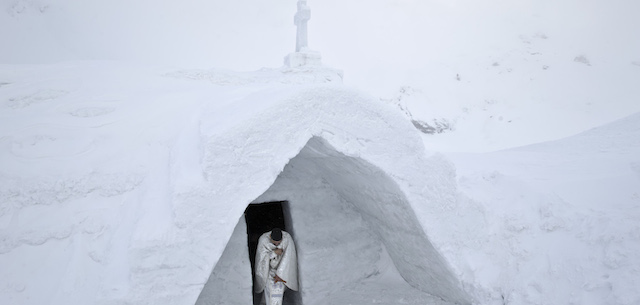 U prete esce dalla chiesa costruita interamente con blocchi di ghiaccio
(AP Photo/Vadim Ghirda)