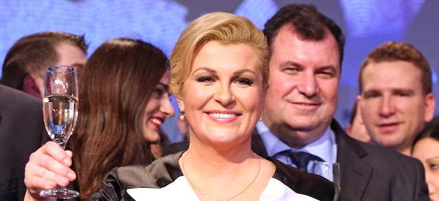 The presidential candidate of the conservative Croatian Democratic Union (HDZ), Kolinda Grabar-Kitarovic (C), toasts next to her husband Jakov (R) as she celebrates on January 11, 2015 after hearing the first results of the Croatian presidential elections in Zagreb. Grabar-Kitarovic was elected Croatia's first female president on January 11, winning a tight run-off vote with a pledge to kickstart the ailing economy, almost complete results showed. Grabar-Kitarovic, an ex-foreign minister and former NATO official, won 50.4 percent of the vote, according to results based on more than 99 percent of the ballots cast. Her rival, centre-left incumbent Ivo Josipovic, garnered 49.6 percent of the vote, according to the results released by the electoral commission. AFP PHOTO / STRINGER (Photo credit should read -/AFP/Getty Images)