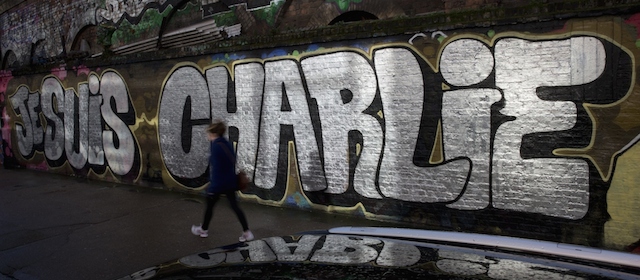 A pedestrian walks past graffiti that reads "Je suis Charlie" (I am Charlie), referring to the movement in solidarity with the victims of the attack on the Paris offices of the satirical French publication Charlie Hebdo, in east London on January 10, 2015. French forces were frantically hunting for the girlfriend of an Islamist gunman as the country mourned 17 dead in three blood-soaked days that shook the nation to its core. After President Francois Hollande warned the threats facing France "weren't over" and Islamist groups issued chilling warnings of fresh attacks, authorities pursued 26-year-old Hayat Boumeddiene, said to be "armed and dangerous." AFP PHOTO / JUSTIN TALLIS -- RESTRICTED TO EDITORIAL