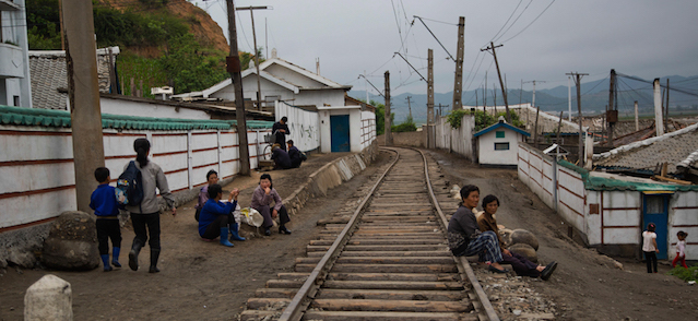 Alcune persone si riposano sui binari, in una città della provincia di North Hamgyong, il 20 giugno 2014. (AP Photo/David Guttenfelder)