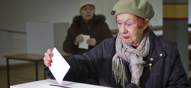 A voter casts her ballot at a polling station in Zagreb, Croatia, Sunday, Jan. 11, 2015. A liberal incumbent and a conservative rival are heading into a surprisingly close showdown in Croatia's presidential runoff held amid deep discontent over economic woes in the European Union's newest member. (AP Photo/Darko Bandic)