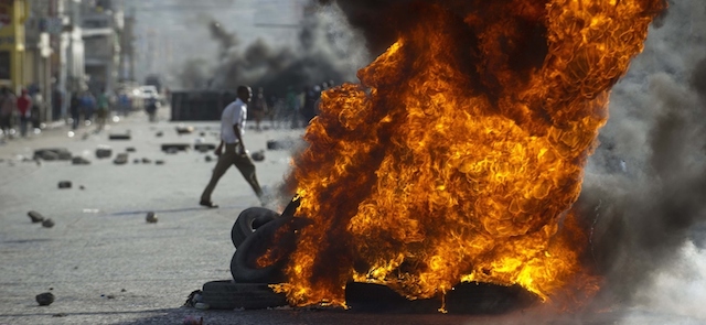 Pneumatici che bruciano durante una manifestazione anti-governativa a Port-au-Prince, l'11 gennaio 2015.
(HECTOR RETAMAL/AFP/Getty Images)