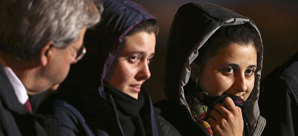 Greta Ramelli (C) and Vanessa Marzullo (R), two Italian aid workers taken hostage in Syria five months ago, arrive at Ciampino airport flanked by Italy's Foreign Minister Paolo Gentiloni in Rome January 16, 2015. In August 2014, Italy's Foreign Ministry said the pair were taken hostage while seeking to provide healthcare assistance in the embattled northern city of Aleppo. REUTERS/Alessandro Bianchi (ITALY - Tags: CRIME LAW POLITICS)