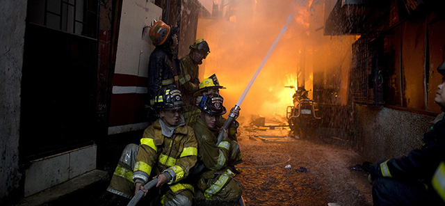 Firemen try to extinguish a fire in a slum area in Manila on January 1, 2015. An estimated 4,000 persons and 200 homes were affected by the fire and one person is confirmed dead on the first day of 2015, according to local media reports. AFP PHOTO / NOEL CELIS (Photo credit should read NOEL CELIS/AFP/Getty Images)