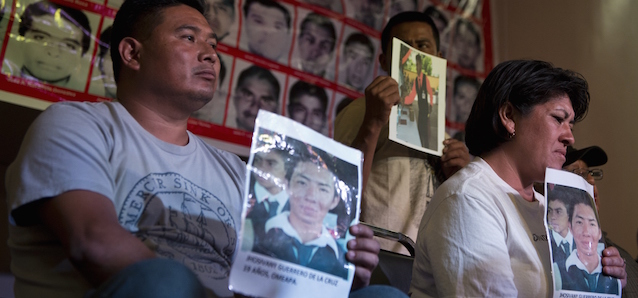 Relatives pose with portraits of the 43 missing students during a press conference in Mexico city, on January 27, 2015. Mexico's Attorney General Jesus Murillo Karam said the investigation gave them "the legal certainty that the students were killed". Witness and expert testimony "have allowed us to... come to the conclusion beyond a doubt that the students were abducted and killed, before being incinerated and thrown into the San Juan river, in that order," he said. AFP PHOTO / RONALDO SCHEMIDT (Photo credit should read RONALDO SCHEMIDT/AFP/Getty Images)
