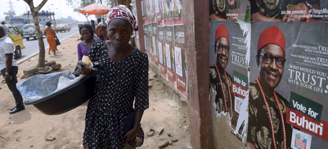 A woman walks past a poster bearing a picture of leading opposition All Progressive Congress presidential candidate Mohammadu Buhari along the highway in Lagos on January 14, 2015. Nigerians go to the polls in a month's time to elect a new president against a backdrop of a raging Boko Haram insurgency, economic troubles and persistent concerns over rampant corruption. President Goodluck Jonathan is hoping to win a second, four-year term at the February 14 vote but is expected to be run close by former military ruler Muhammadu Buhari. AFP PHOTO / PIUS UTOMI EKPEI (Photo credit should read PIUS UTOMI EKPEI/AFP/Getty Images)