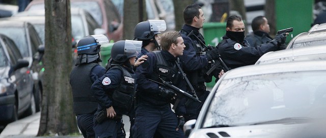 Police stand with their weapons drawn as they surround a bank during an attempted robbery in Paris, near Porte de Saint-Mande, on January 9, 2015. AFP PHOTO / MATTHIEU ALEXANDRE (Photo credit should read MATTHIEU ALEXANDRE/AFP/Getty Images)