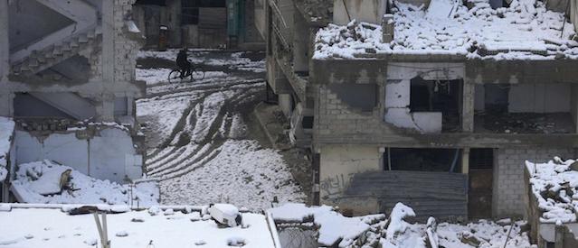 A man rides a bicycle past damaged buildings covered with snow in the Duma neighborhood of Damascus January 8, 2015. Nobody was reported killed by fighting in Syria on Wednesday, the first day without casualties in three years, after a fierce winter storm quelled violence, a group that monitors the war said on Thursday. REUTERS/Bassam Khabieh (SYRIA - Tags: POLITICS CIVIL UNREST SOCIETY CONFLICT ENVIRONMENT)