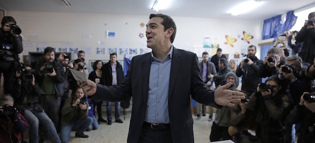 Alexis Tsipras, leader of Greece's Syriza left-wing main opposition party surrounded by photographers reacts as he casts his vote at a polling station in Athens, Sunday, Jan. 25, 2015. Greeks were voting Sunday in an early general election crucial for the country's financial future, with the radical left Syriza party of Alexis Tsipras tipped as the favorite to win, although possibly without a large enough majority to form a government. (AP Photo/Lefteris Pitarakis)