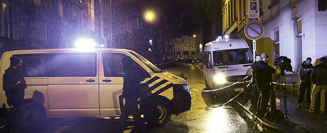 Journalists and residents stand near police vehicles as police set a large security perimeter in the city center of Verviers on January 15, 2015, during a "jihadist-related" anti-terrorism operation. Belgian police launched a "jihadist-related" anti-terrorism operation in the eastern town of Verviers today, with reports saying three people had been killed. AFP PHOTO / BELGA / BRUNO FAHY ***BELGIUM OUT*** (Photo credit should read BRUNO FAHY/AFP/Getty Images)