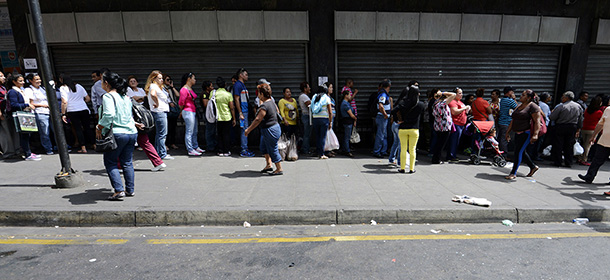 People queue outside a supermarket in Caracas on February 2, 2015. The price of the family shopping basket in Venezuela increased 93.2% in 2014, almost reaching the equivalent to US 5,000 dollars at the official rate, the teachers' union Centre for Documentation and Social Analysis reported. AFP PHOTO/JUAN BARRETO (Photo credit should read JUAN BARRETO/AFP/Getty Images)
