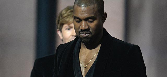 Winner for Album Of The Year Beck (background) reacts as Kanye West leaves the stage at the 57th Annual Grammy Awards in Los Angeles February 8, 2015. AFP PHOTO / ROBYN BECK (Photo credit should read ROBYN BECK/AFP/Getty Images)