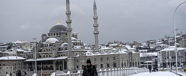 A man walks on the Galata bridge under heavy snow in the European side of Istanbul, on February 18, 2015. AFP PHOTO/BULENT KILIC (Photo credit should read BULENT KILIC/AFP/Getty Images)
