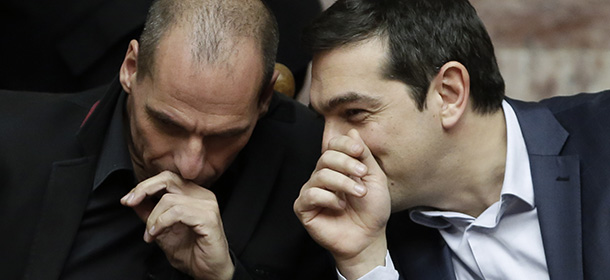 Greece's Prime Minister Alexis Tsipras talks with Greece's Finance Minister Yanis Varoufakis, left, during a Presidential vote in Athens, on Wednesday, Feb. 18, 2015. Greece’s parliament has elected conservative law professor and veteran politician Prokopis Pavlopoulos as the country’s next president, after he received support from the new left-wing government and main center-right opposition party.(AP Photo/Petros Giannakouris)