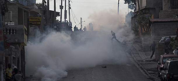 Police fire tear gas towards protesters during a protest march in Port-au-Prince, Haiti, Saturday, Feb. 7, 2015. Several thousand protesters marched through Haiti's capital to demand lower gas prices and the ouster of President Michel Martelly. ( AP Photo/Dieu Nalio Chery)