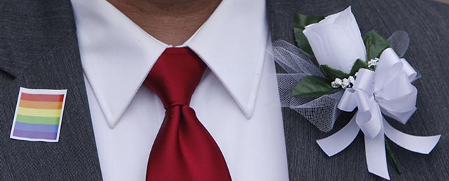 Pat Helms wears a sticker, tie and flower as he and partner Curtis Stephens wait for the Jefferson County courthouse doors to open so they can be legally married Monday, Feb. 9, 2015, in Birmingham, Ala. A federal judge's order overturning the state's ban on gay marriage goes into effect on Monday, making Alabama the 37th state to allow gays and lesbians to wed. (AP Photo/Hal Yeager)