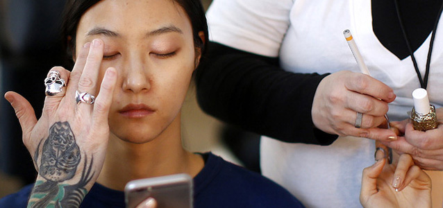 Model Jihye Park, of South Korea, has her makeup and nails done backstage before the DelPozo Fall 2015 collection show during Fashion Week, Wednesday, Feb. 18, 2015, in New York. (AP Photo/Jason DeCrow)