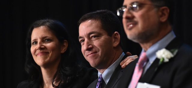 Laura Poitras (L) and Glenn Greenwald (C), in the US for the first time since documents were disclosed to them by former intelligence analyst Edward Snowden, accept Long Island University's George Polk Award for National Security Reporting April 11,2014 in New York. The two journalists are sharing the award with The Guardian's Ewen MacAskill (not pictured) and Barton Gellman (R) of The Washington Post. AFP PHOTO/Stan HONDA (Photo credit should read STAN HONDA/AFP/Getty Images)