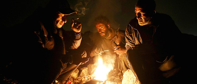 Tossicodipendenti si drogano attorno a un fuoco in un quartiere di Teheran, 11 febbraio 2015. 
(AP Photo/Ebrahim Noroozi)