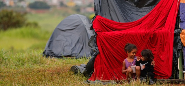 Estafani, 5 anni (a destra), e Amanda, 7 anni (a sinistra), giocano fuori dalla loro tenda nel campo del Movimento dei Lavoratori senza casa in un quartiere di Brasilia, Brasile. 
(AP Photo/Eraldo Peres)