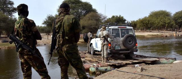 A picture taken on January 27, 2015 shows Chadian soldiers watching as a UN vehicle from a United Nations' refugee agency (UNHCR) convoy crosses a branch of lake Chad, heading to the UNHCR camp in N'Gouboua, in Chad's Lake Chad region. Since the beginning of January more than 14,000 people have fled over the Nigerian border into Chad to escape the bloody attacks by Islamist group Boko Haram around Baga, according to Mamadou Dian Balde, of the UN's refugee agency. AFP PHOTO/ SIA KAMBOU (Photo credit should read SIA KAMBOU/AFP/Getty Images)