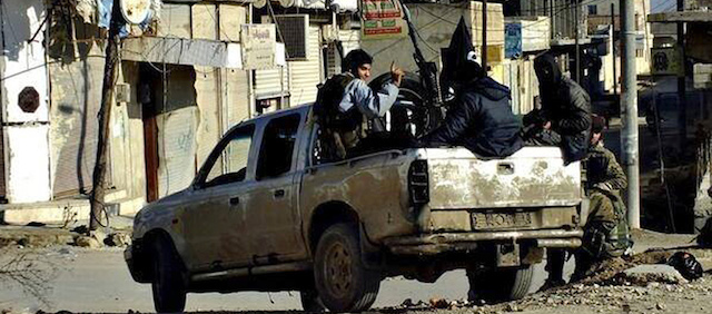FILE - This undated file image posted on a militant website on Tuesday, Jan. 14, 2014 shows fighters from the al-Qaida linked Islamic State of Iraq and the Levant (ISIL) patrolling in Raqqa, Syria. The ISIL led by Abu Bakr al-Baghdadi, who is believed to have been operating from inside Syria in recent months, is the main driver of destabilizing violence in Iraq and until recently was the main al-Qaida affiliate there. Al-Qaida’s general command formally disavowed the group this week, saying it "is not responsible for its actions." (AP Photo/militant website, File)