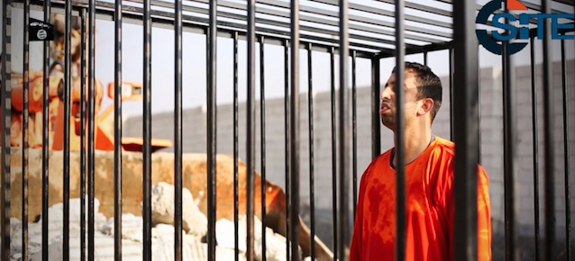 FILE - This still image made from video released by Islamic State group militants and posted on the website of the SITE Intelligence Group in this Tuesday, Feb. 3, 2015 file photo, purportedly shows Jordanian pilot Lt. Muath al-Kaseasbeh standing in a cage just before being burned to death by his captors. The video featured production techniques used in other clips from the militants. But unlike those that showed beheadings in which the hostages or their killer delivered a message before being killed, the pilot video is longer and involves a story-telling narrative and at least four cameras, along with advanced editing techniques. The death of the 26-year-old pilot, who fell into the hands of the militants in December when his Jordanian F-16 crashed near Raqqa, Syria, followed a weeklong drama over a possible prisoner exchange. (AP Photo/SITE Intelligence Group, File)