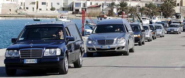 Hearses with the remains of migrants who died in a shipwreck arrive at the Lampedusa harbour February 11, 2015. An estimated 300 people probably died this week after attempting to reach Italy from Libya in stormy weather, the U.N. refugee agency said on Wednesday after speaking to a handful of survivors. REUTERS/Antonio Parrinello (ITALY - Tags: SOCIETY IMMIGRATION TRANSPORT MARITIME)